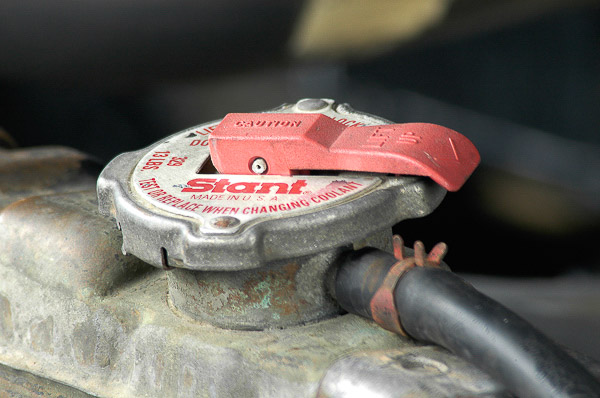 Radiator cap with latch release.