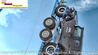Jeep JK Wrangler hoisted into the air with a boom crane